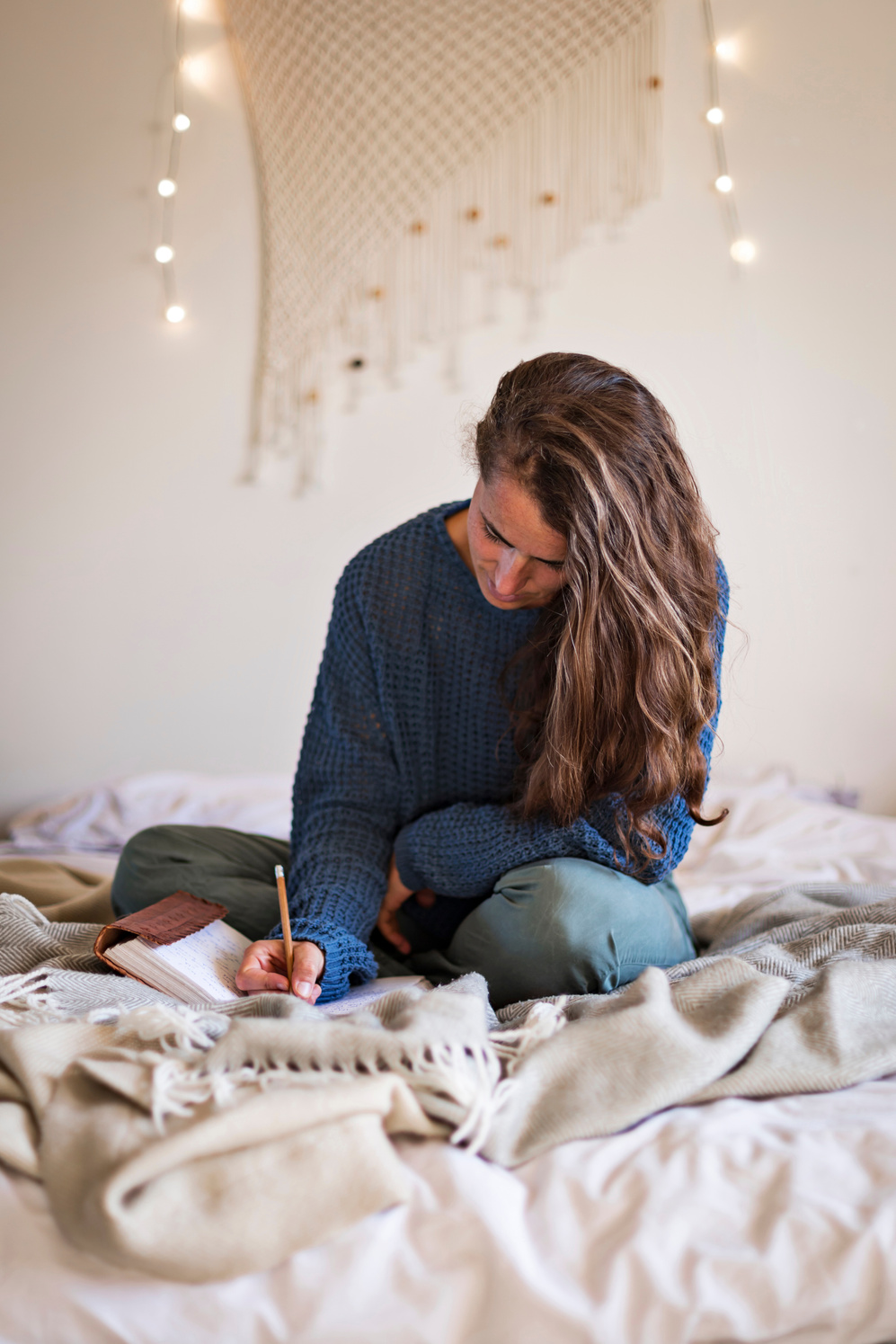 Woman on bed writing in her journal